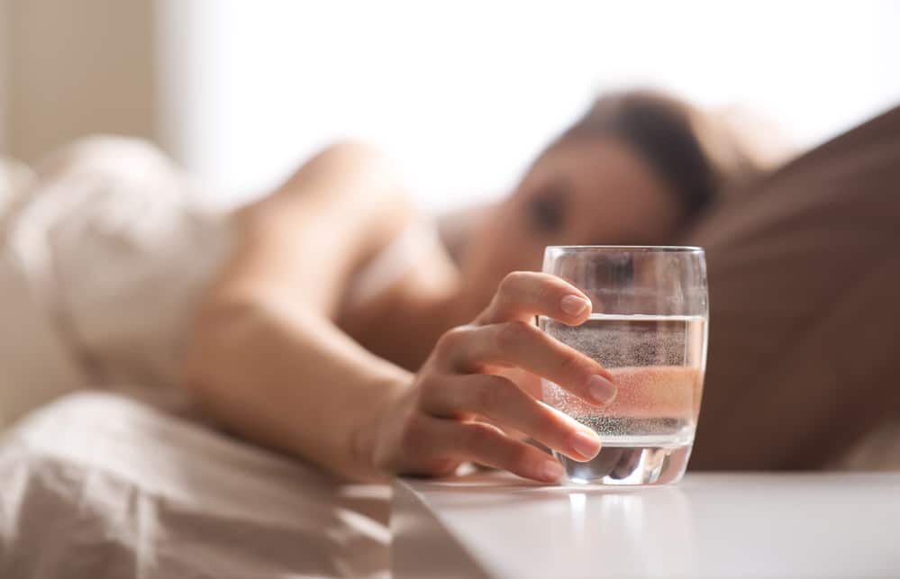 woman having a glass of water before bed