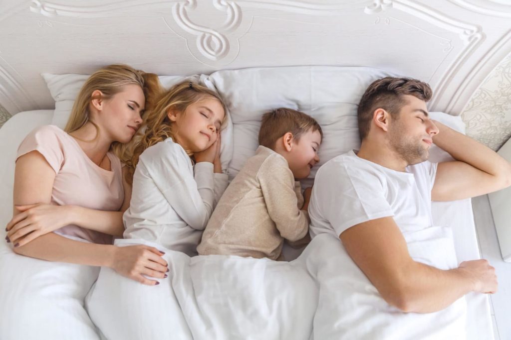 Kids and parents sleeping in one bed