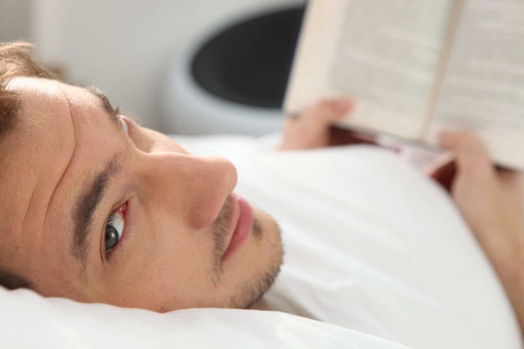 man reading in bed