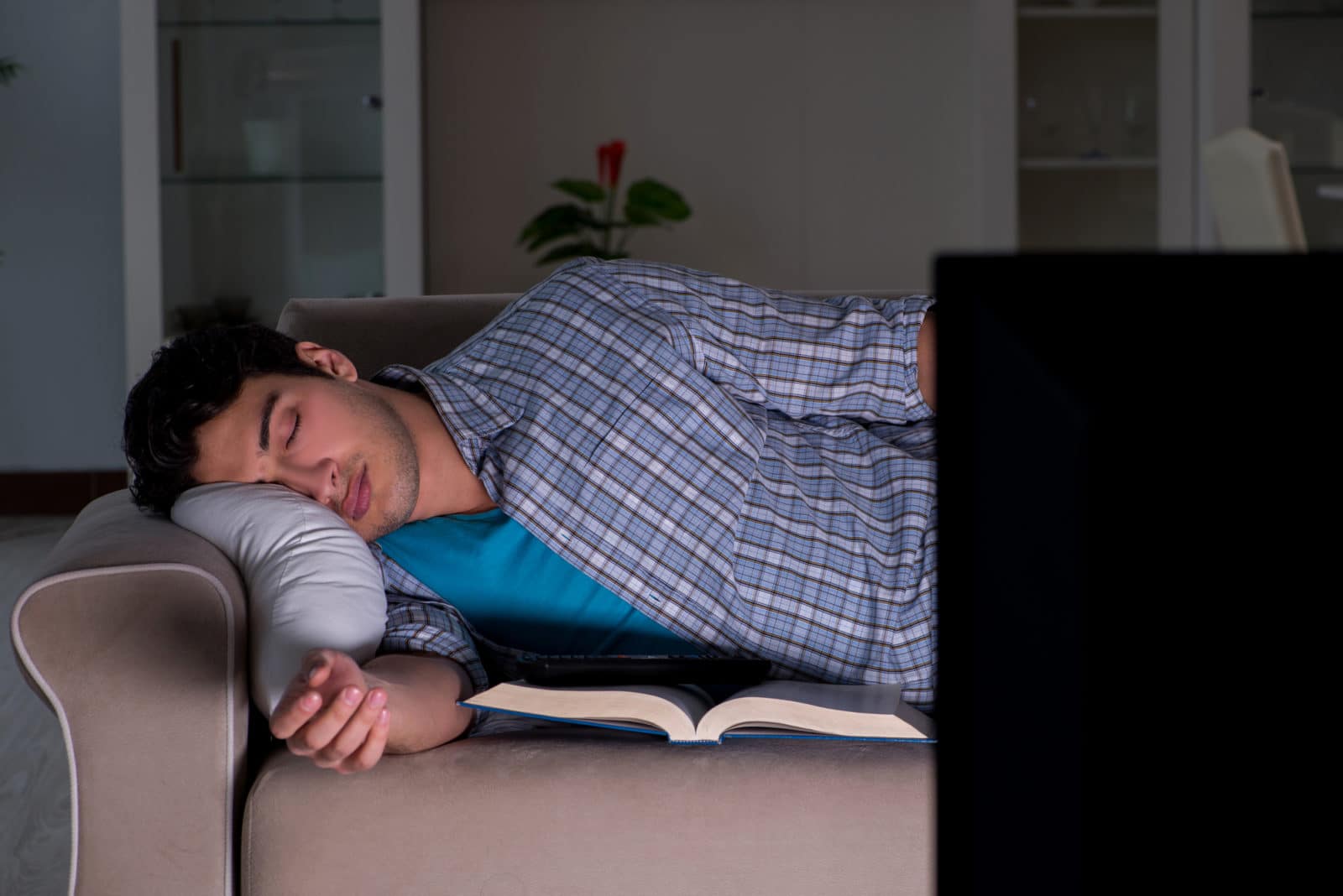 a young man falling asleep while watching tv