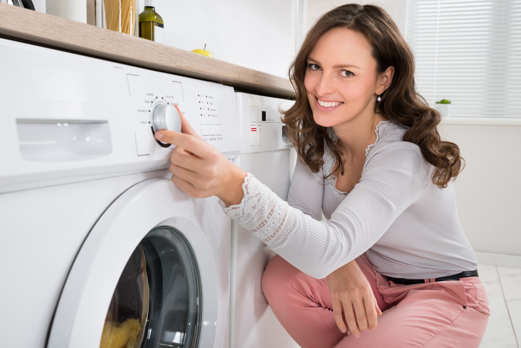 woman adjusting washing machine settings