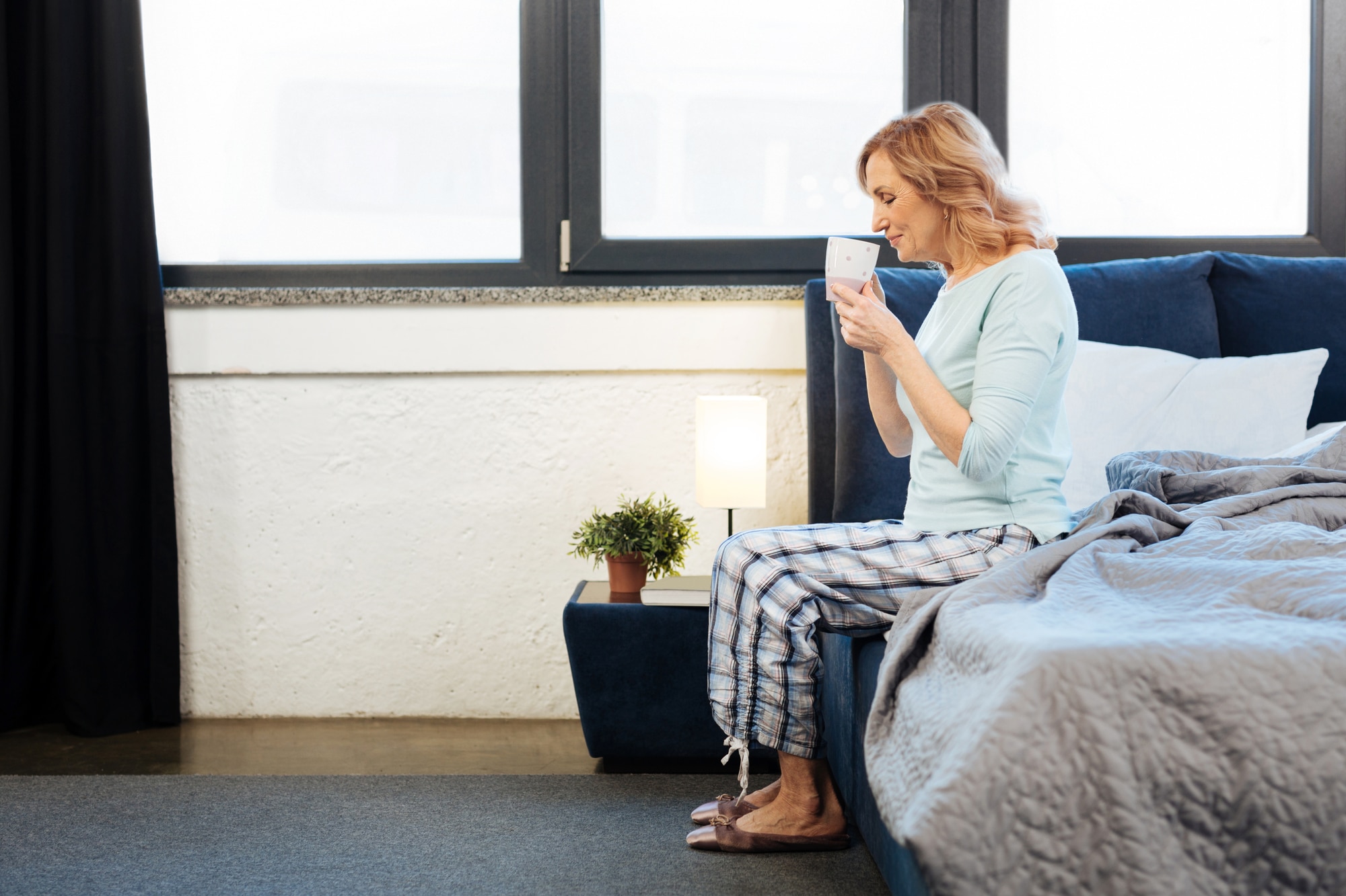 mature woman sitting on edge of bed