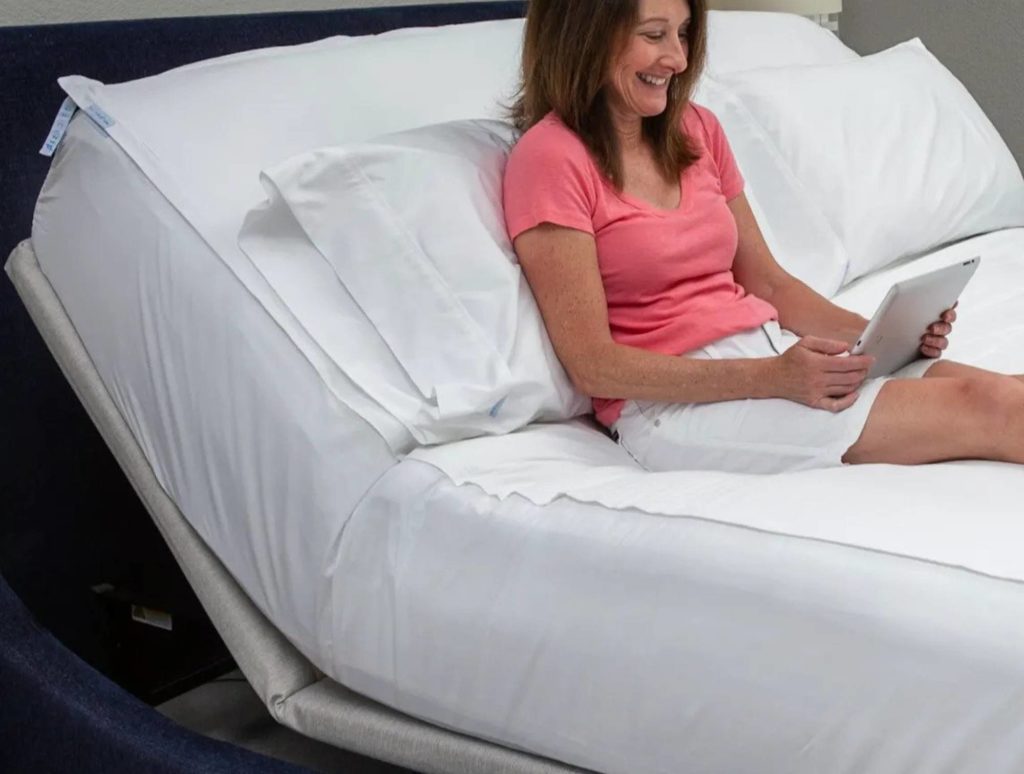 a woman sitting on a reclining mattress