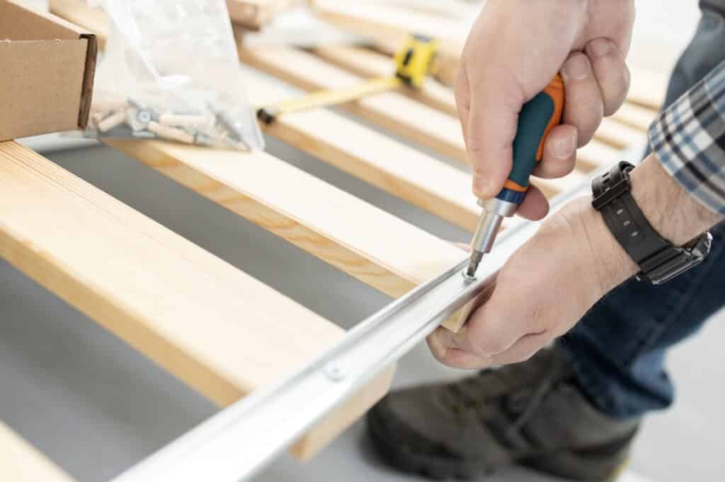 Close up of a hands Assembling a bed frame using a screwdriver